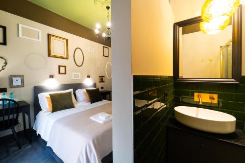 a bathroom with a bed and a sink and a mirror at Iconic Rooms Verona in Verona