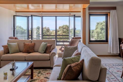 a living room with two couches and a table at Vista Atlântica-Vila do Conde in Vila do Conde
