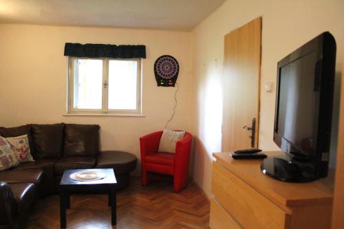 a living room with a couch and a red chair at Chata na Bunči in Roštín