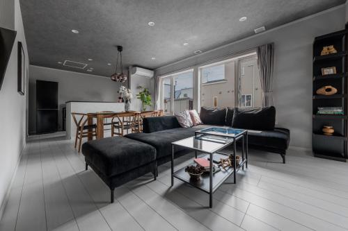 a living room with a couch and a table at THE Shelbourne Furano in Furano