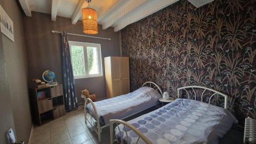 a bedroom with a bed in a room with a wallpaper at Maison au coeur des Châteaux de la Loire in Seuilly