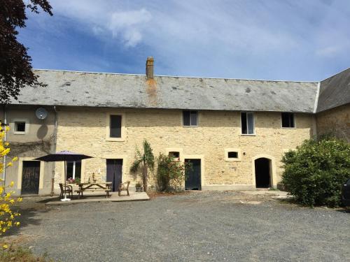 a large brick building with a picnic table in front of it at Holiday Home in Saint-Clément near the Sea in Osmanville