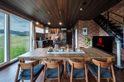 a dining room with a large wooden table and chairs at The Horizon Residence in Makubetsu