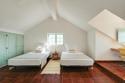 zwei Betten in einem Zimmer mit Dachboden in der Unterkunft Charneca Caparica Casa Rey by Hopstays in Vale de Cavalos