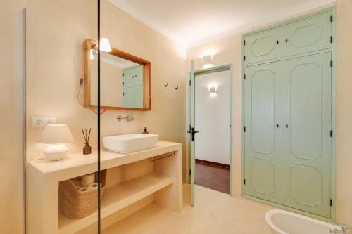 ein Badezimmer mit Waschbecken und Spiegel in der Unterkunft Charneca Caparica Casa Rey by Hopstays in Vale de Cavalos