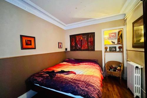 a bedroom with a bed with a colorful comforter at 16th 10 minutes from the Eiffel Tower Metro line 9 in Paris