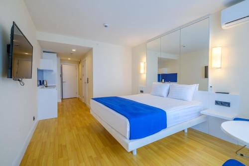 a bedroom with a large white bed and a sink at Orbi City Collection in Batumi