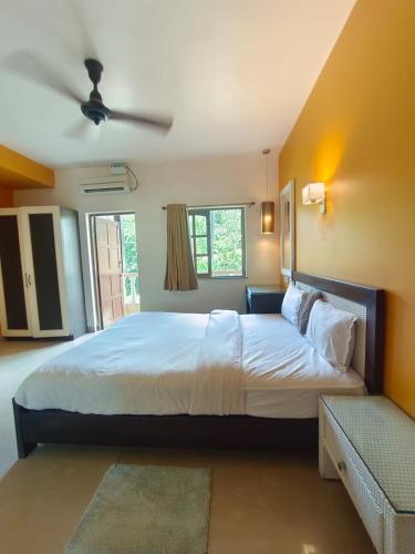 アーポラにあるHotel Coco Goaの大きなベッドと窓のある寝室