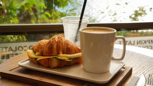 un panino su un piatto accanto a una tazza di caffè di Reev Coffee House a Antalya (Adalia)