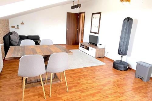 a living room with a wooden table and white chairs at 2-room apartment near Xbionic-sphere and Bratislava in Nová Lipnica