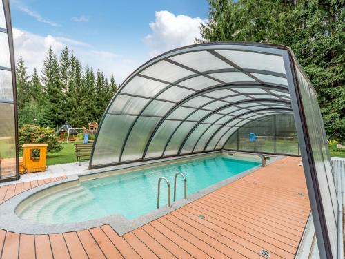 a swimming pool with a retractable arch over it at Forest Retreat in Jägersgrün in Bad Reiboldsgrün