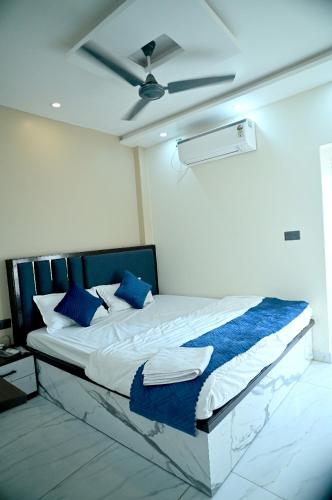 a bedroom with a bed with blue pillows and a ceiling at Hotel Krishna Kashi Diaries in Jāmb