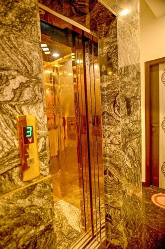 a glass shower in a room with a stone wall at Hotel Krishna Kashi Diaries in Jāmb