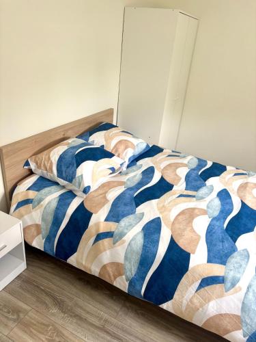 une chambre avec un lit avec une couette bleue et blanche dans l'établissement Renovated 3-Bedroom Apartment near UTT, à Troyes