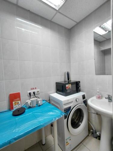 a bathroom with a washing machine and a sink at apartments with shared bathroom in Cherkasy