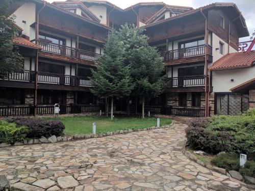 an apartment building with a tree in the courtyard at Relax in Banyas Hidden Gem - Igzila appartment in Banya