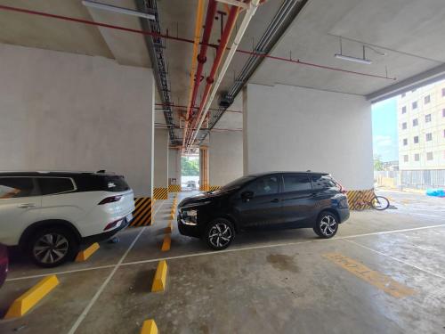 due auto sono parcheggiate in un parcheggio di Mountain City Condo Room for Rent in Quezon City a Manila