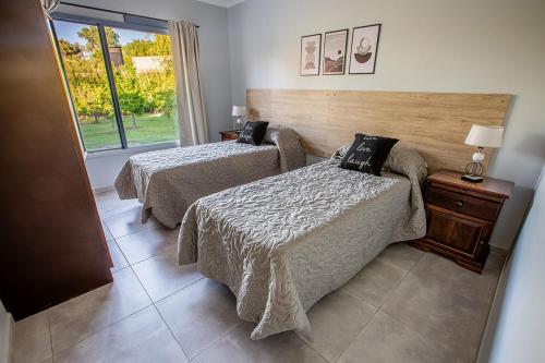 ein Hotelzimmer mit zwei Betten und einem Fenster in der Unterkunft Posada Maral, San Rafael in San Rafael