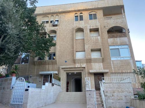 アンマンにあるzainab houseの正面に階段がある大きなレンガ造りの建物