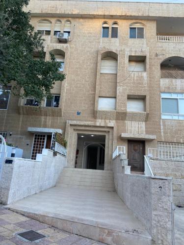 アンマンにあるzainab houseの正面に階段がある大きなレンガ造りの建物