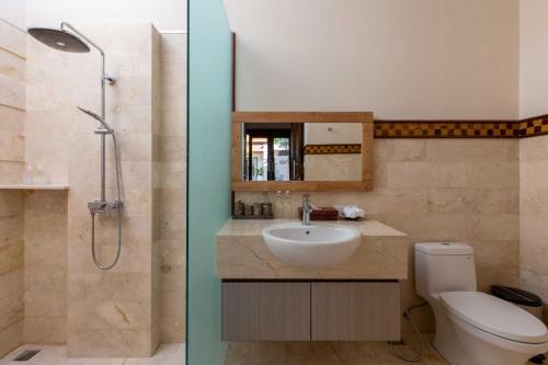 a bathroom with a sink and a shower and a toilet at Villa Stella - Tranquillity by the beach in Sanur