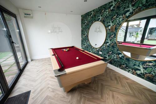 a room with a pool table and a mirror at Modern 5-Bed Retreat with Parking in Cockett
