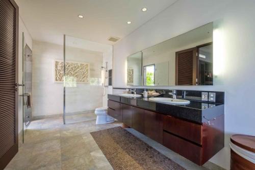 a bathroom with two sinks and a large mirror at Kejora Beachfront Estate Sanur -Stunning Villa Eleven in Sanur