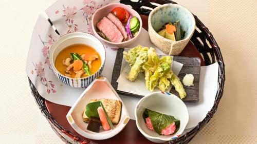 ein Tisch mit mehreren Schüsseln Essen drauf in der Unterkunft LiVEMAX Resort Nasu Kogen in Nasu