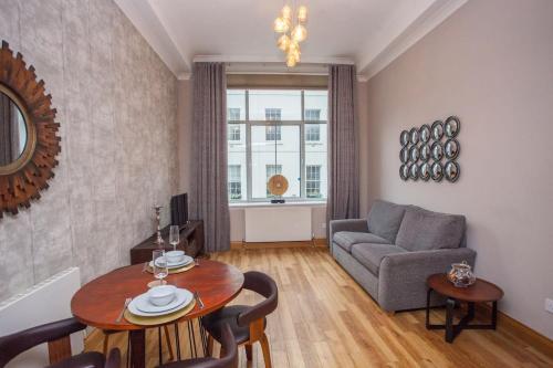 a living room with a table and a couch at Stylish Merchant City Flat Glasgow in Glasgow