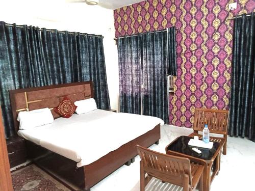 a bedroom with a bed and a table and chairs at hotel zora grand in Visakhapatnam