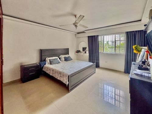 a bedroom with a bed and a ceiling fan at Stylish La Romana Apartment with 2-Way Air Con Covered Parking in Batey Río Dulce