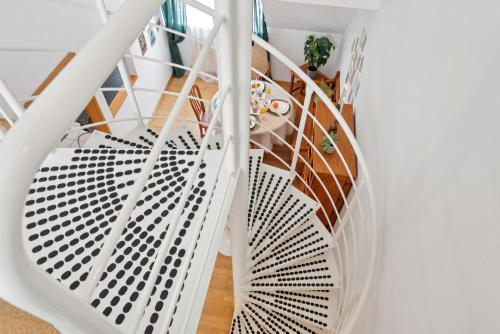 un escalier en colimaçon avec des balustrades blanches dans une maison dans l'établissement "Gelbe Koffer Vintage Maisonette" in Neunkirchen - 2 SZ - Self-Check-in - Parkplatz - Balkon - Badewanne - WLAN 250 Mbit - bis 4 Pers - zentrumsnah, à Neunkirchen