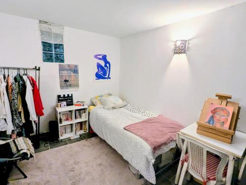 une chambre avec un lit et une table avec un tableau dans l'établissement Appart calme et confortable Père Lachaise, à Paris