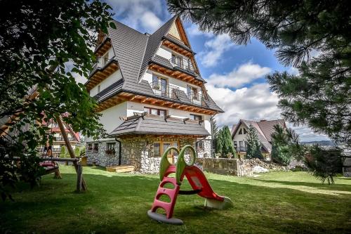 a house with a slide in front of a house at U Gronikowskich in Zakopane