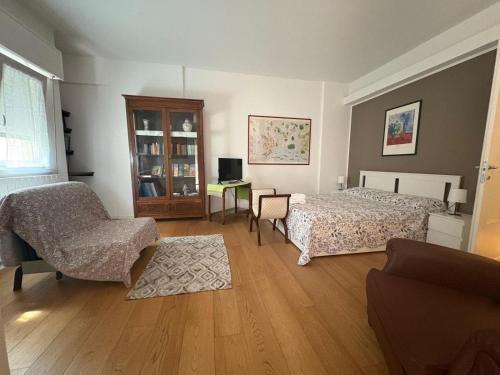 a bedroom with two beds and a chair and a desk at una casa tranquilla in Palermo