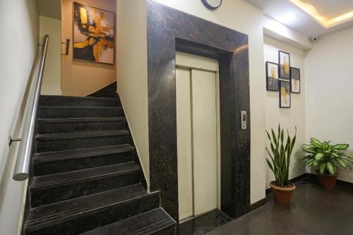 a staircase in a building with a door and plants at Via Shivani Residency in Mumbai