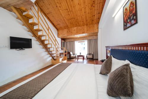 a large bedroom with a bed and a staircase at Hotel Monal in Manāli