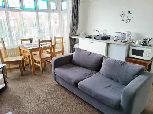 a living room with a blue couch and a kitchen at Bats7 in Lincolnshire