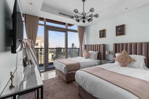 a hotel room with two beds and a television at Burj Khalifa Downtown Views - Highest Infinity Pool in Downtown in Dubai