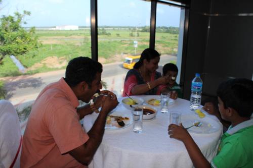 a group of people sitting around a table eating food at Ebenezer Plaza in Nedumbassery