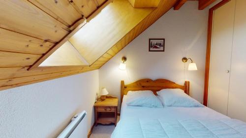 a bedroom with a bed and a wooden ceiling at Refuge des pistes in Métabief