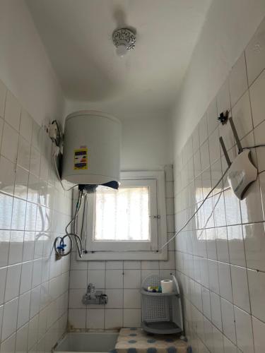 a bathroom with a sink and a window and a tub at NubaNest GuestHouse in Aswan