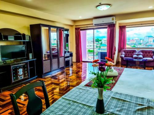 a living room with a vase of flowers on a table at Yamadaya Apartment in Phra Nakhon Si Ayutthaya