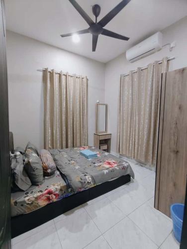 a bedroom with a bed and a ceiling fan at Homestay Triple S SAKINAH kangar in Kangar