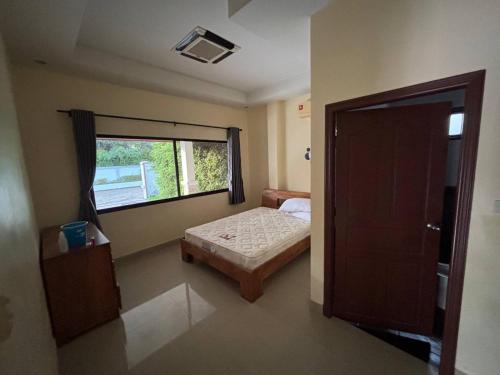 a small bedroom with a bed and a window at Unique Paradise Resort in Ban Map Fakthong