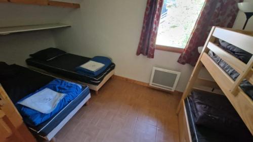 圣索林达尔沃Duplex avec piscine - Les Chalets de Saint Sorlin的一间有两张双层床和一扇窗户的小房间