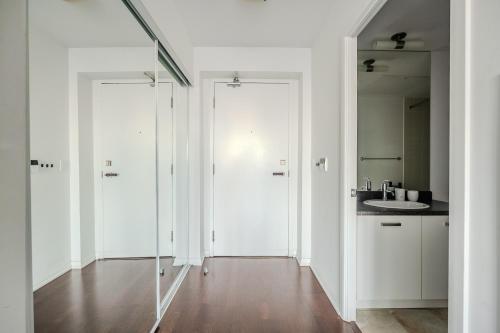 a white bathroom with a sink and a mirror at High Floor 1 Bedroom Condo City View Downtown Toronto in Toronto