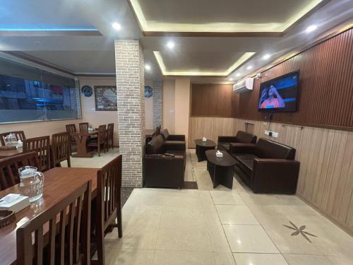 un salon avec un canapé et une télévision sur un mur dans l'établissement Hotel White Palace Airport Kathmandu, à Pashupatināth