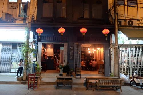 a building with tables and chairs and lanterns on it at X Stay On Sukhumvit Soi 11 BTS Nana in Makkasan