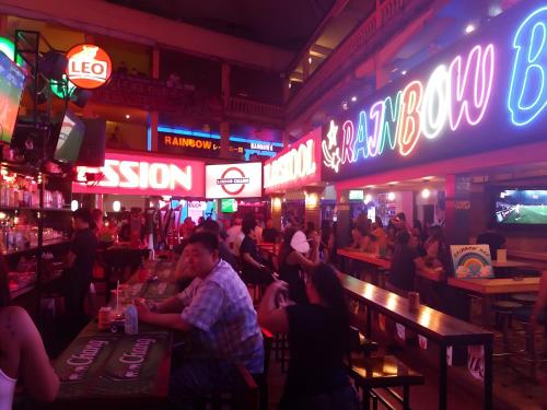 a group of people in a bar with neon signs at X Stay On Sukhumvit Soi 11 BTS Nana in Makkasan